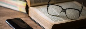 Eyeglasses and Book on desk